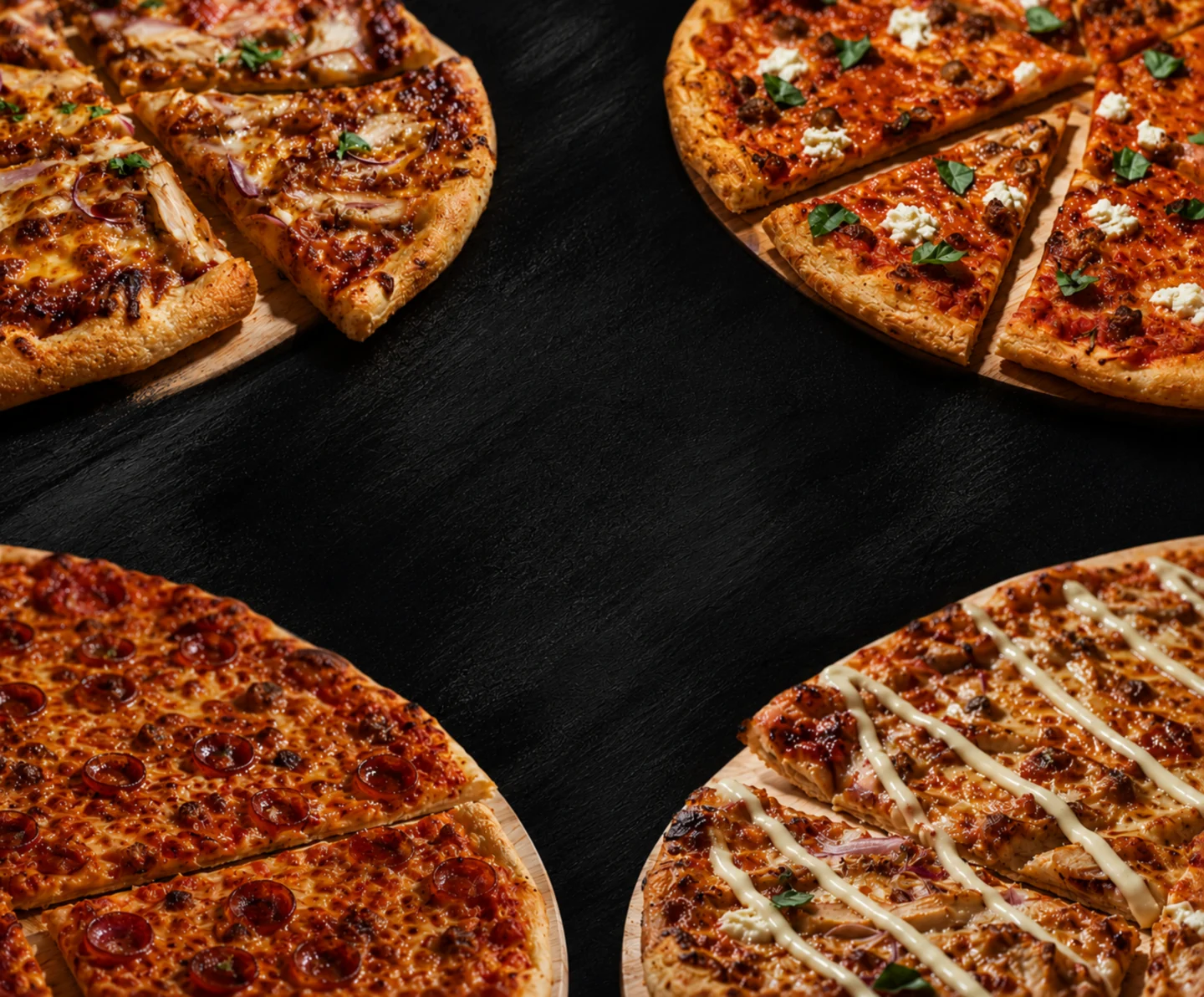 Four Sinners pizzas arranged around a dark tabletop