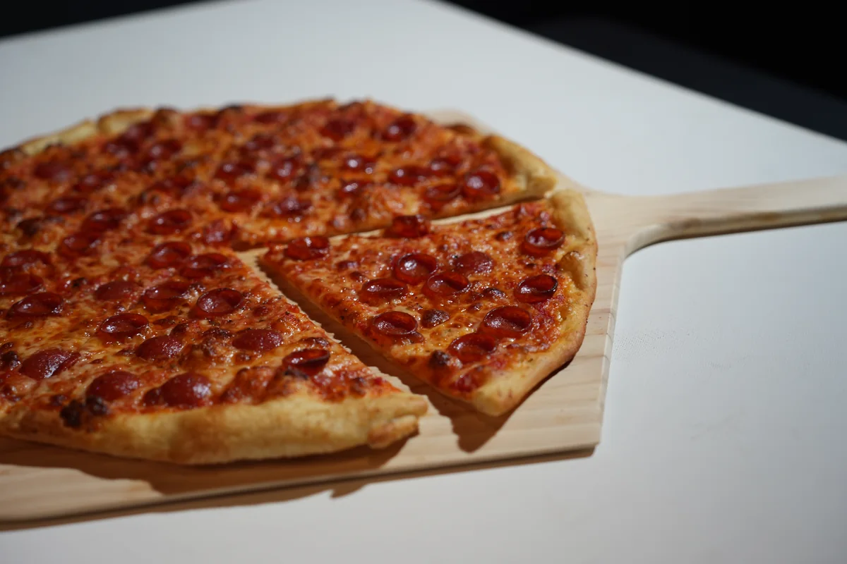 The Politician pepperoni pizza with a slice pulled forward